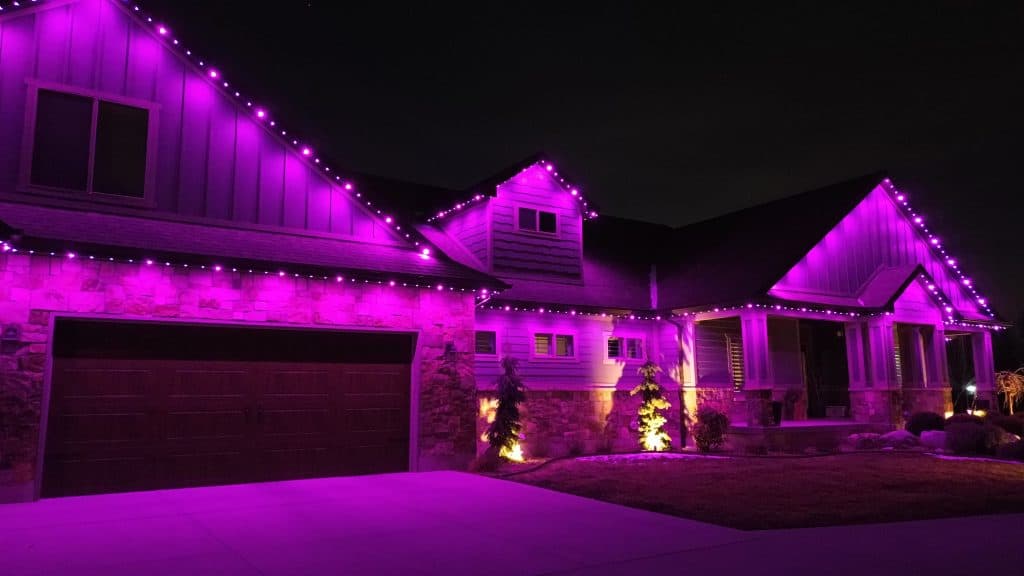 Wide aerial view of home with permanent LED lighting at night