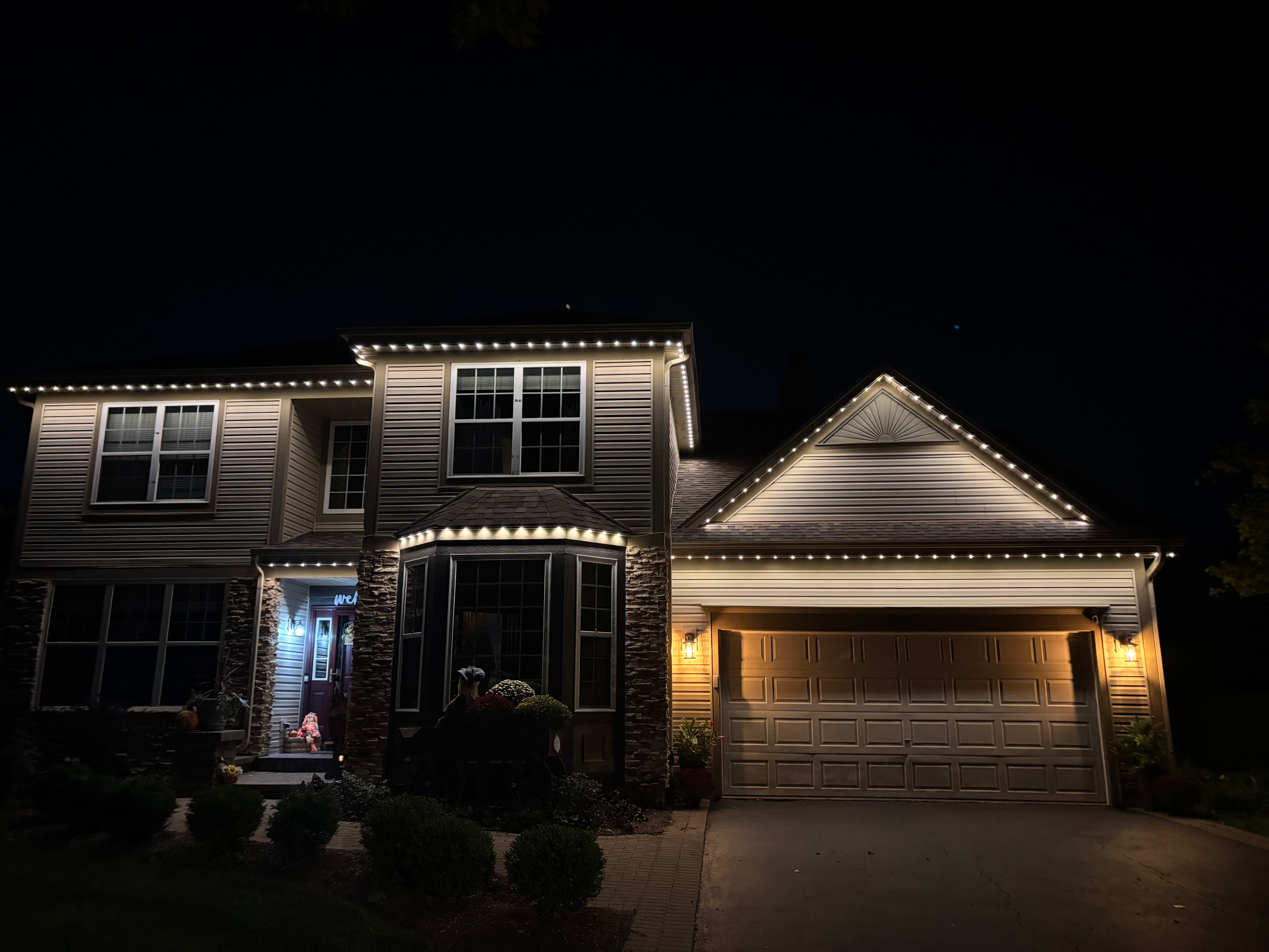 Two story home with clean white LED roofline lighting