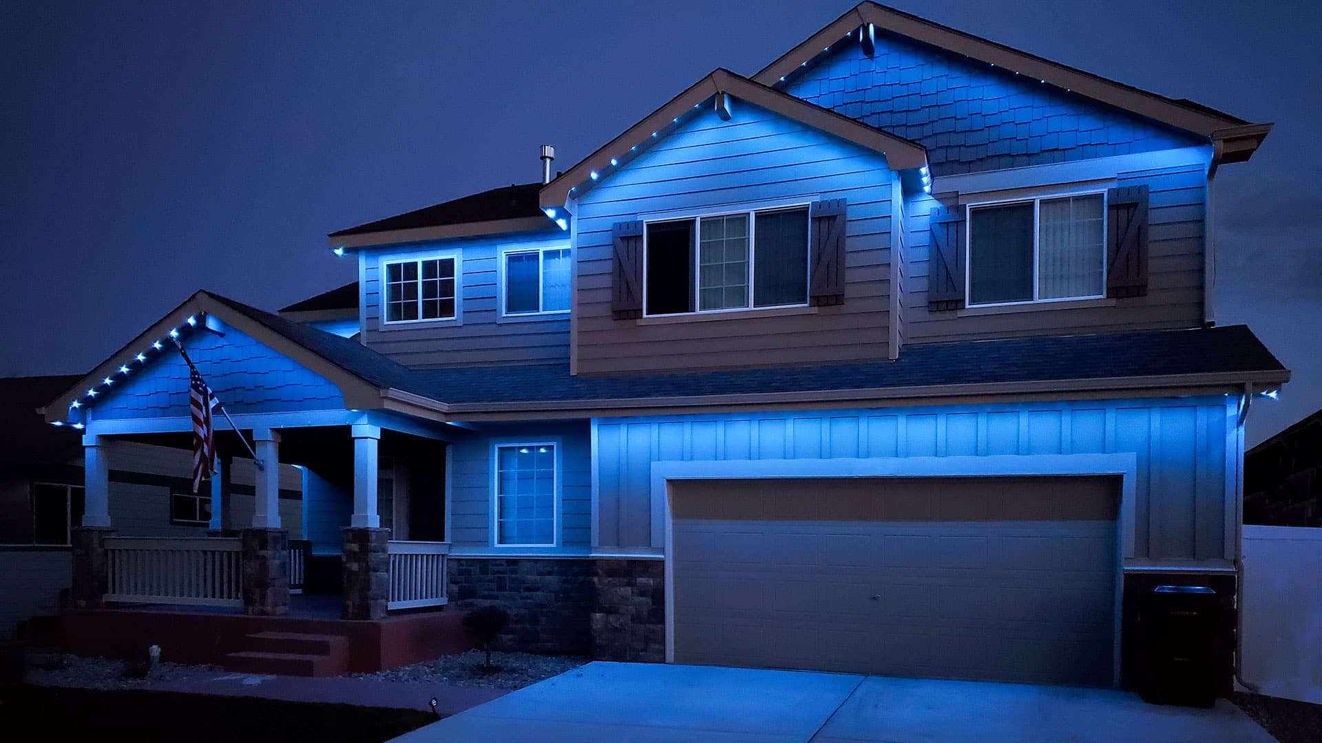 Wood siding home with cool white LED roofline lighting